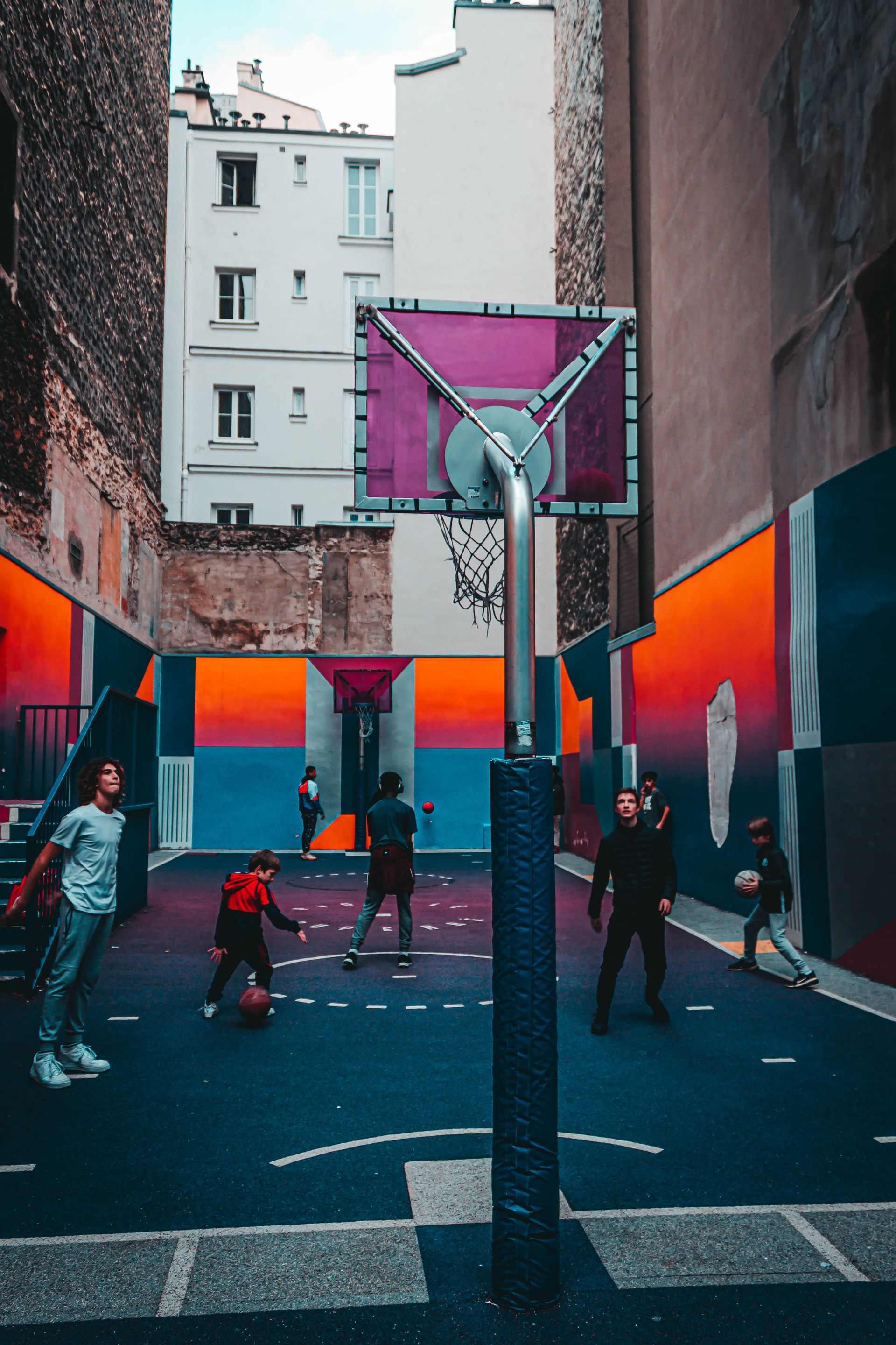 Adolescents jugant a bàsquet en una pista urbana