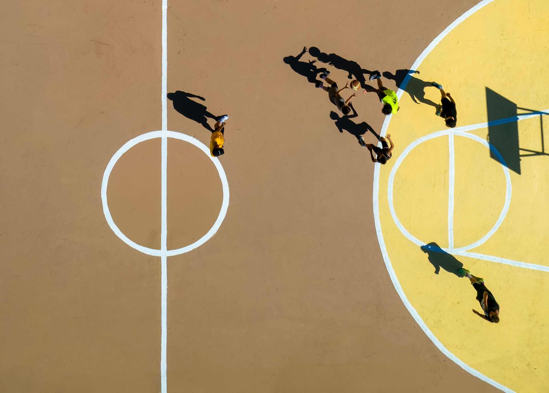 Jugadors de bàsquet en una pista pública de barri