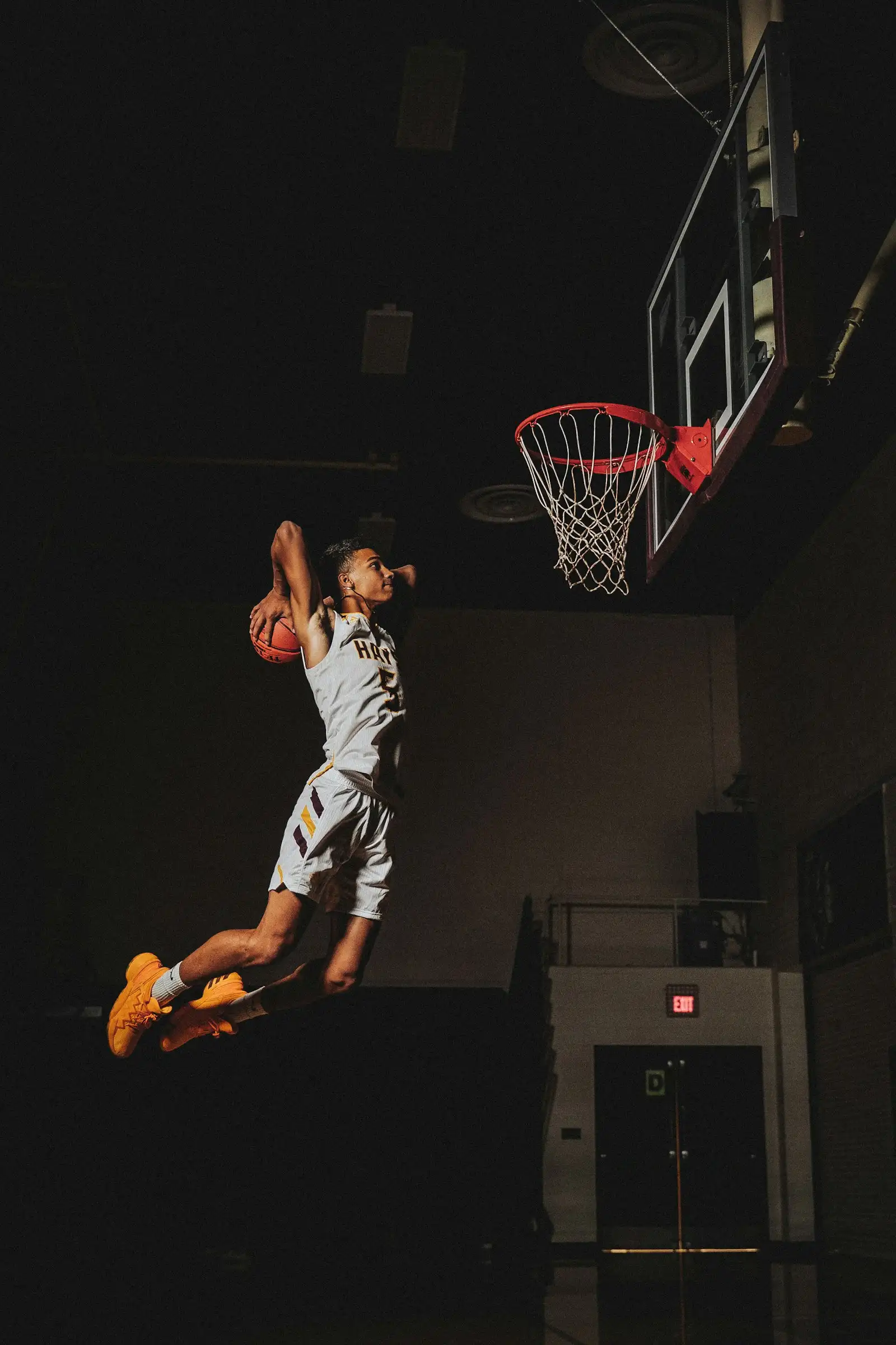 Player dunking on a dark indoor court